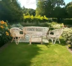 a garden with white wicker furniture and yellow flowers