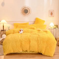 a bed with yellow comforter and pillows in a room