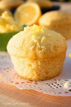 a close up of a muffin on a doily with lemons in the background