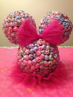 a minnie mouse head made out of candy candies on a pink tablecloth with a red bow