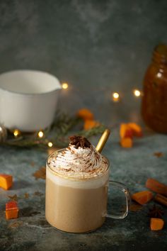 there is a cup of coffee with whipped cream on top and cinnamon sticks sticking out of it