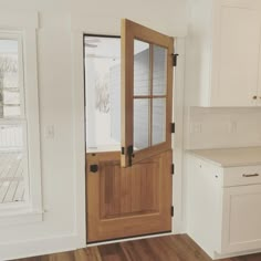 an empty kitchen with white cabinets and wooden doors, wood floors, and hardwood flooring