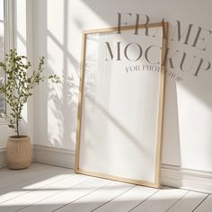 an empty frame next to a plant in front of a wall with the words prime mocaup on it