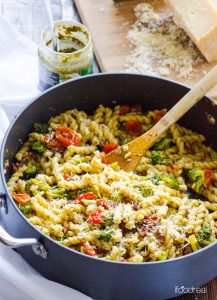 a pan filled with pasta and vegetables on top of a table