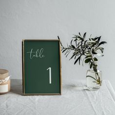 there is a vase with flowers in it next to a chalkboard that says table 1