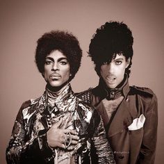 two people standing next to each other in front of a blue sky and one person has an afro on his head