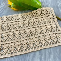 a crocheted doily on a table next to a green leafy plant