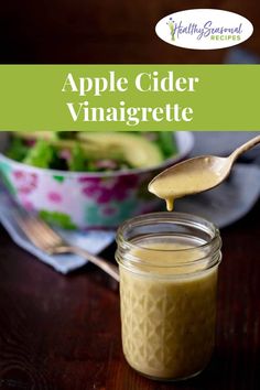 an apple cider vinaigrette in a jar with a spoon on the side