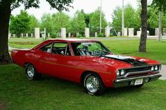 an old red car parked in the grass