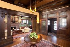 a large living room with wood paneling and chandelier