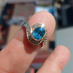 This stunning Sterling Silver Ring features a mirror polished finish and showcases a beautiful oval cut blue Zircon as the centerpiece, accented by 22 white CZ stones for added sparkle.  US Ring Size 5.5 The Ring is hallmarked 925 and measures 12 mm along the finger, making it a perfect statement piece for any occasion.  With a Zircon dimension of 8 mm x 6 mm, this Cocktail Ring is a unique and elegant gift for her that is sure to impress. Blue Zircon Ring, Natural Gemstone Ring, 925 Ring, Zircon Ring, Ring Oval, Blue Zircon, Jewelry Maker, Cz Stone, Cocktail Ring