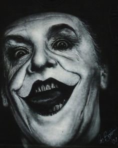 a black and white photo of a man with his face painted as the joker