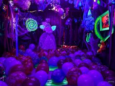 a room filled with purple and green balloons