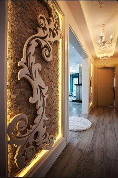 a hallway with wood floors and lights on the wall, along with a rug that looks like a dog bed