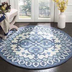 a blue and white area rug in front of a window with flowers on the floor