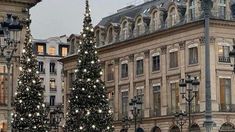 there are many christmas trees in front of the buildings