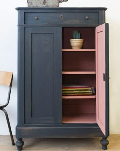 a blue cabinet with pink doors and shelves