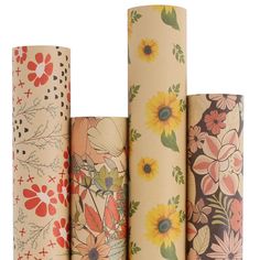 four rolls of toilet paper are lined up in different patterns and colors, each with flowers on them