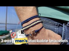 three easy men's stackable bracelets on the beach with boats in the background