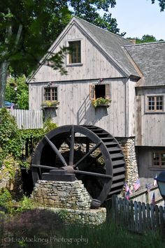 an old water mill in front of a house