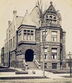 an old black and white photo of a building with stairs leading up to the entrance