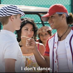 two men and a woman are talking to each other in front of a fence, with the caption i don't dance