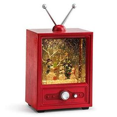 an old fashioned red television with christmas decorations on it's display case and antenna