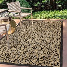 an outdoor area rug with chairs and table