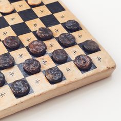 a wooden chess board with black pieces on it