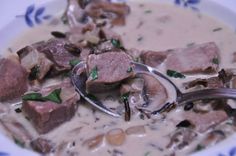 a bowl of soup with meat and mushrooms