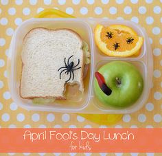 a lunch box with an apple, sandwich and spider on it