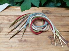 several pairs of knitting needles on a wooden surface