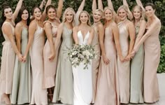 a group of women standing next to each other holding their hands up in the air