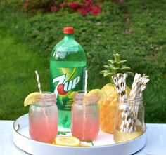 drinks are sitting on a plate with pineapples and lemonade