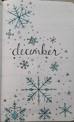 a notebook with snowflakes and the word december written in black ink on it