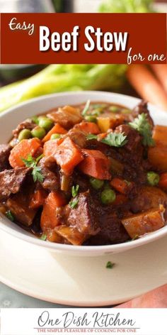 beef stew in a white bowl with carrots and celery on the side