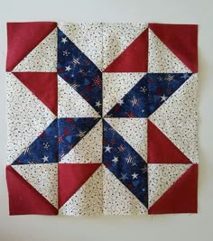 a red, white and blue quilt hanging on a wall