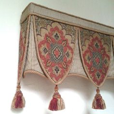 an ornate wall hanging with tassels on it's sides and fringed ends