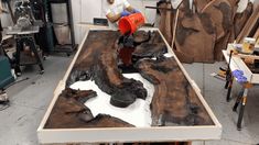 a man is working on a large piece of wood that looks like it has been cut into pieces