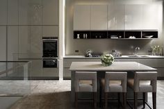 a modern kitchen with stainless steel appliances and white countertops, along with marble flooring