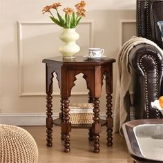 a wooden table with a vase on top of it next to a brown leather chair