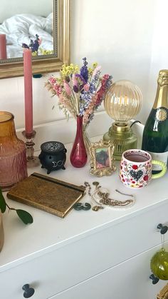 there are many vases and other items on the counter top in this room, including candles