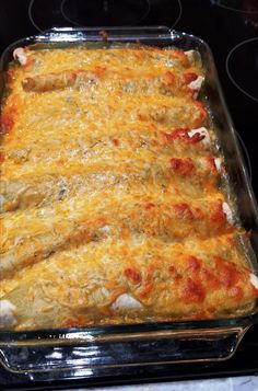 a casserole dish with cheese and meat in it sitting on a stove top