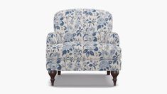 an upholstered chair with blue and white flowers on the back, against a white background