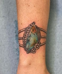 a woman's foot with a tattoo on it that shows the earth in a ring