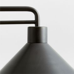 an industrial style lamp with a black metal shade on the top and bottom, against a white background