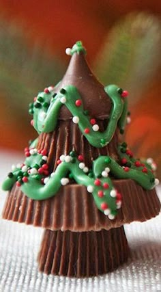 a chocolate christmas tree with green icing and candy sprinkles on top