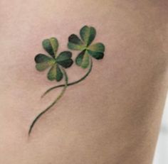 a four leaf clover tattoo on the back of a woman's left thigh,