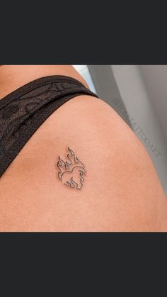 the back of a woman's shoulder with a small tattoo on her left arm