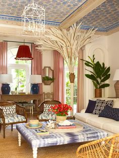 a living room filled with furniture and a chandelier hanging over it's windows